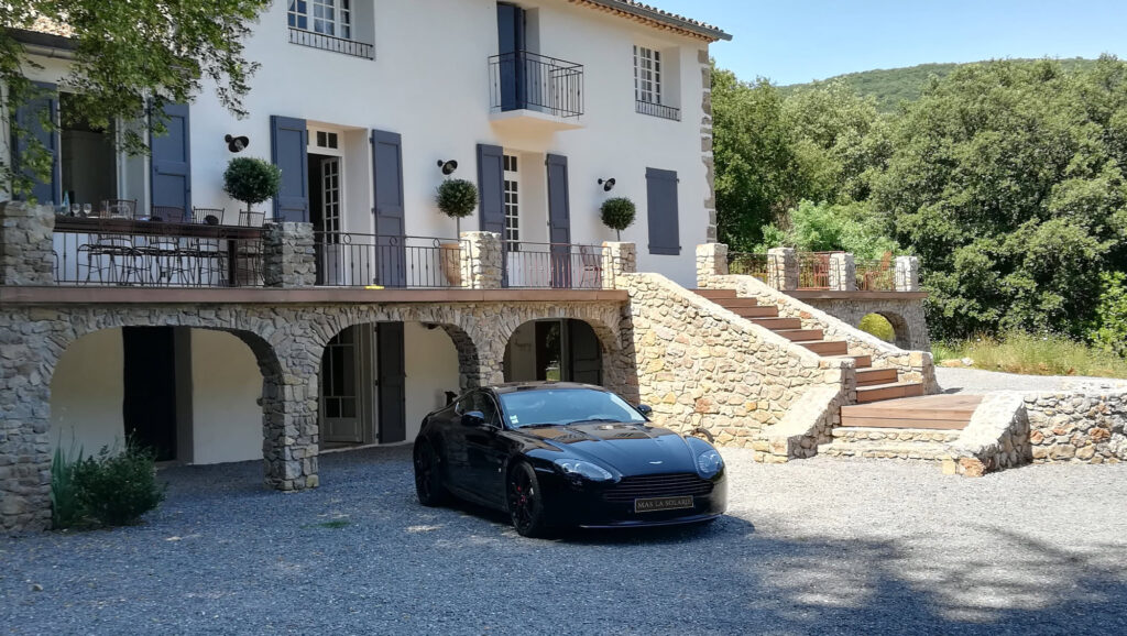 Fa&ccedil;ade du Mas La Solarie avec escalier en pierre et voiture de prestige, lieu de mariage et r&eacute;ception dans les C&eacute;vennes