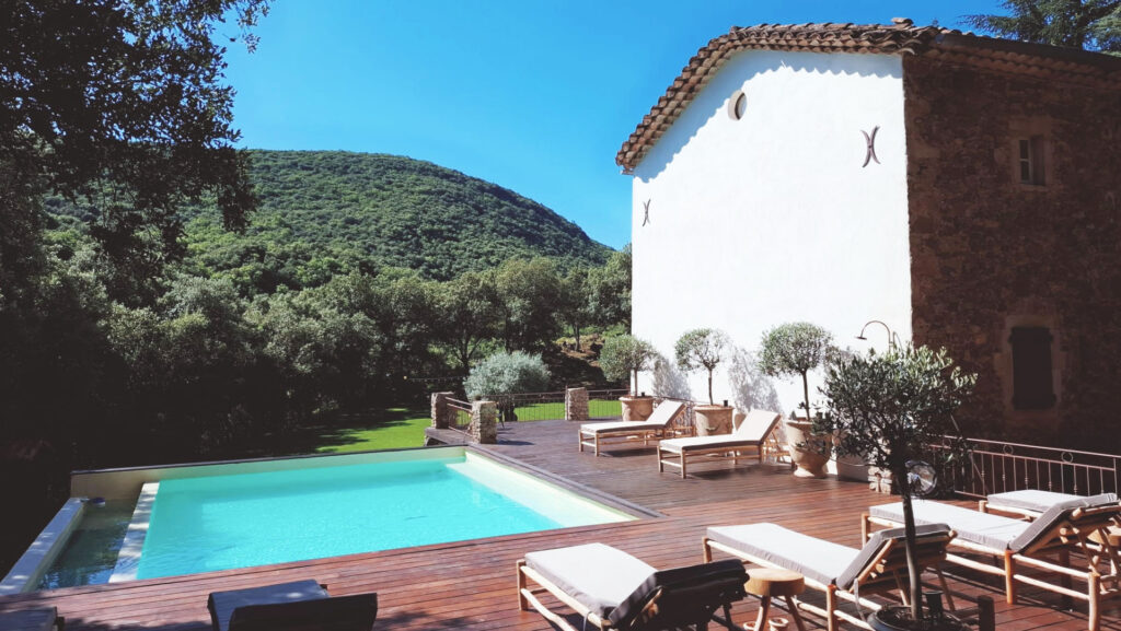 Piscine et terrasse en bois du Mas La Solarie avec vue sur les C&eacute;vennes, lieu de mariage et r&eacute;ception