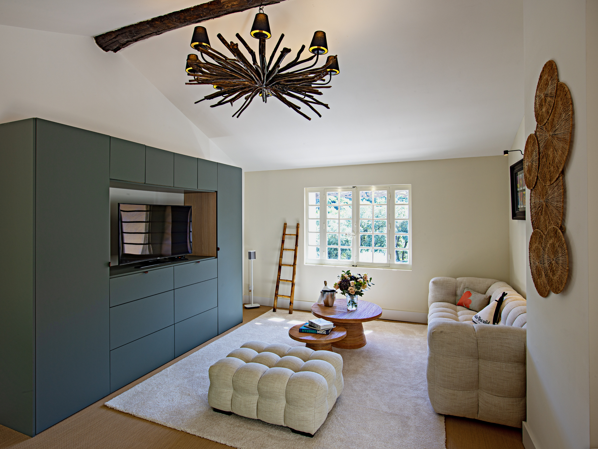 Salon confortable et lumineux – Mas La Solarie Salon lumineux avec canapé et télévision au Mas La Solarie, maison de charme en location saisonnière dans les Cévennes près de Montpellier