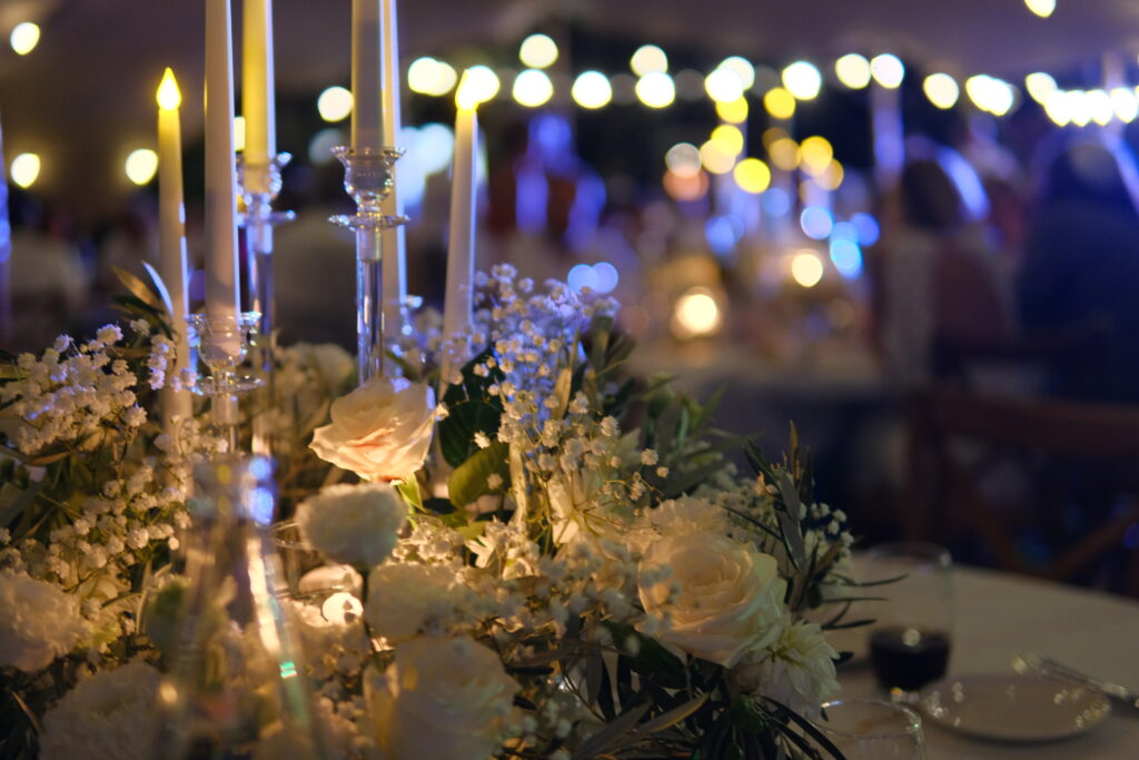 d&eacute;coration florale avec bougies et roses blanches lors d&rsquo;un d&icirc;ner de mariage au Mas La Solarie, lieu de r&eacute;ception dans les C&eacute;vennes &agrave; Anduze